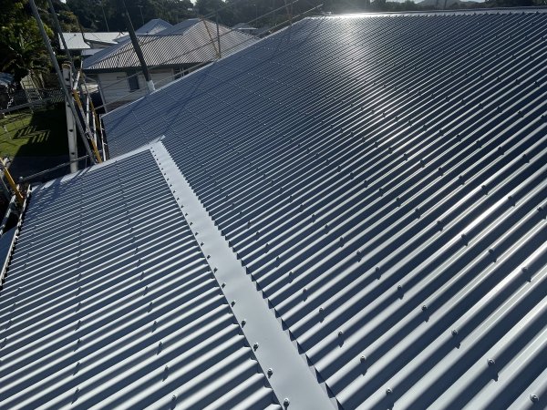 Late sun raking across a finished metal roof with a new capped ridge, Yeppoon