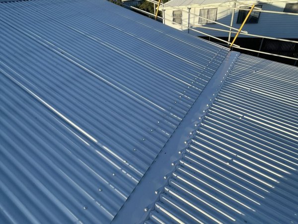 Fresh metal sheeting and ridge capping on a Cooee Bay replacement roof